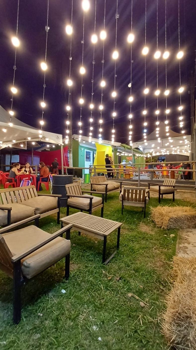 Área de convivência com poltronas, gramado e luzes