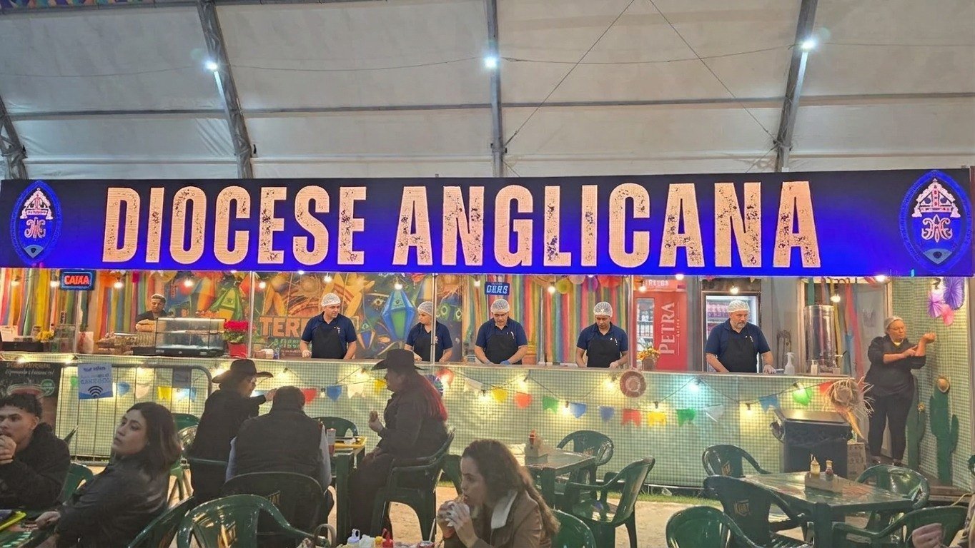 Barraca com letreiro Diocese Anglicana e público nas mesas