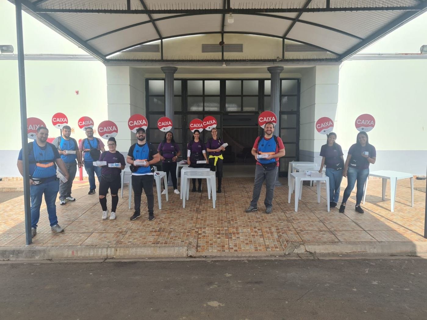 Equipe de caixas uniformizada e posicionada antes da abertura do evento