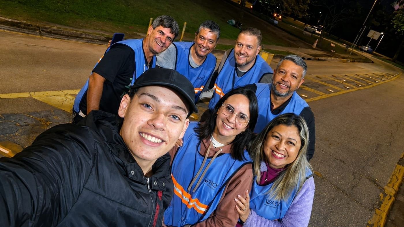 Equipe do estacionamento de colete azul sorrindo para a foto