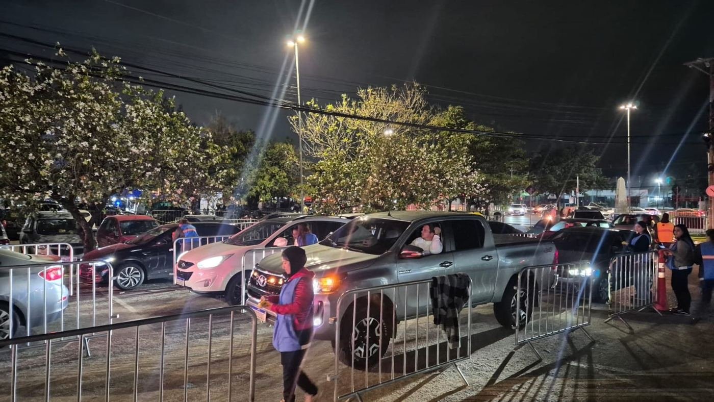 Equipe orientando a entrada de veículos entre gradis