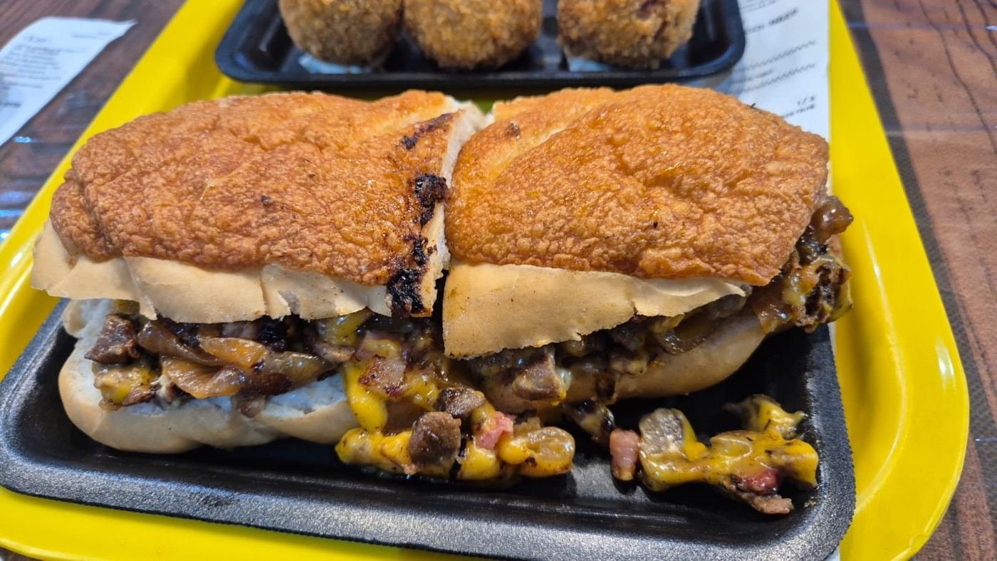 Baguete de carne com queijo derretido na bandeja